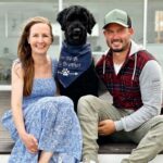 Labradoodle announcing "Soon to be big brother" with navy blue dog bandana for announcement