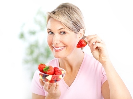 Mujer con menopausia y fresas en blog de fitness para mujeres